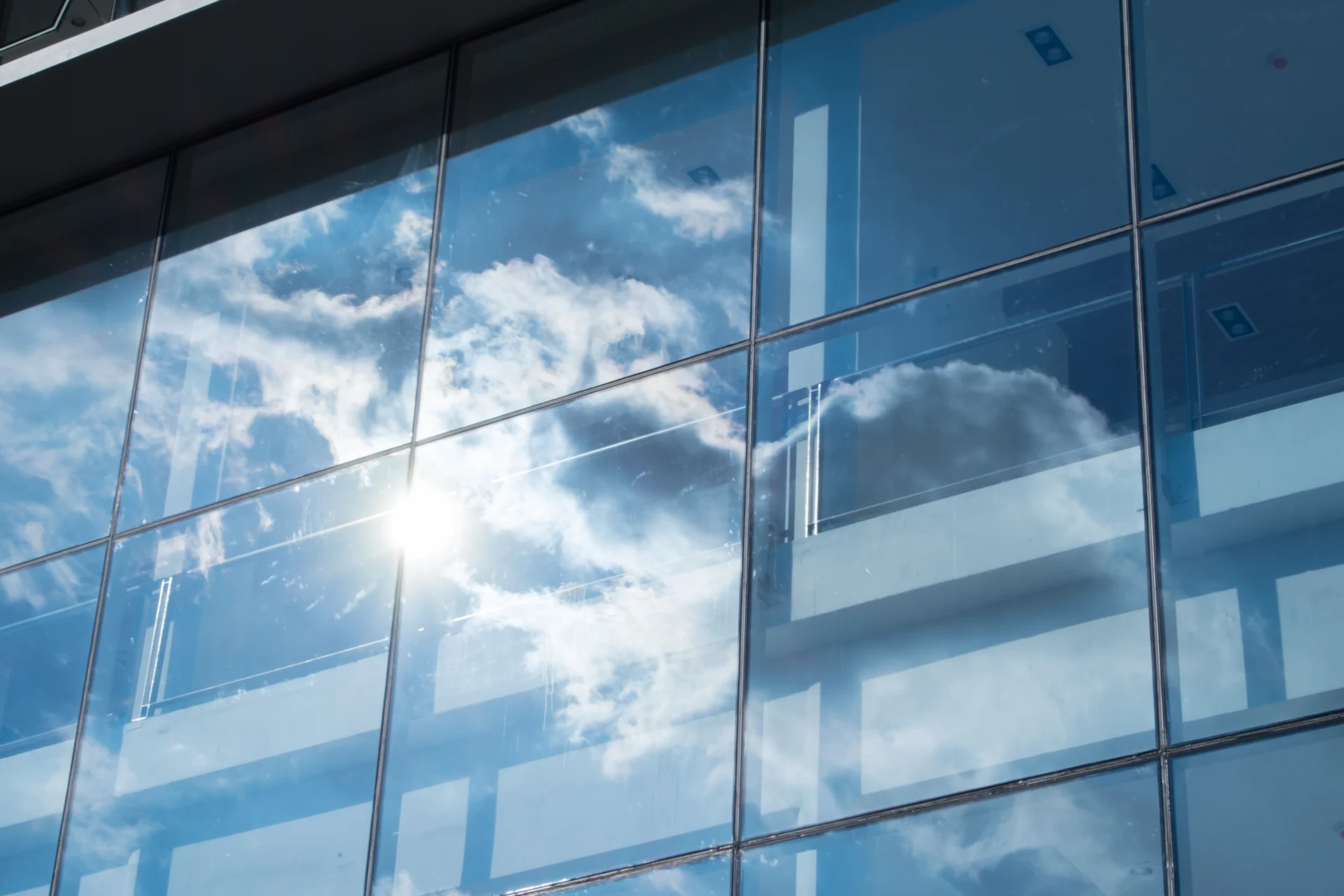 Sauberes Bürofenster mit Spiegelung von blauem Himmel